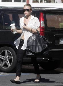 Actress  Ashley Olsen pictures wearing a see through white shirt with a bra under it