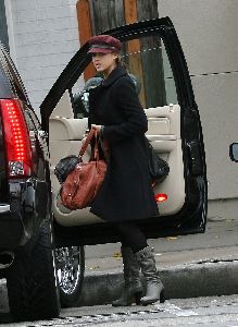 Jessica Alba wearing a black coat and a red rose hat in Los Angeles on December 18th 2007