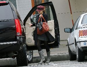 Jessica Alba wearing a black coat and a red rose hat in Los Angeles on December 18th 2007