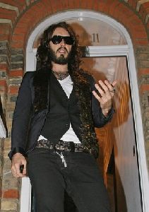 Russell Brand : Russell Brand stands outside his own house in England