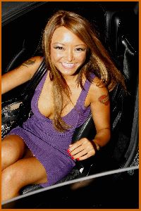 Tila Tequila driving her car wearing a purple short knit dress