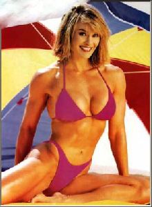 Cory Everson : wearing a pink bikini under a beach umbrella