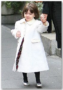 Suri Cruise : I dont know what s more cute, the white coat, the black leggings, or the silver ballet shoe