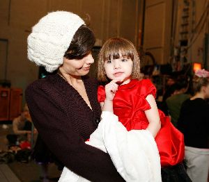 Suri Cruise : Katie Holmes who just turned 30 years old yesterday is holding her daughter Suri who is wearing a red dress