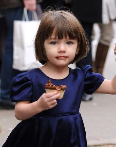 Suri Cruise : Suri holding her mom s hand is eating a chocolate candy sprinkled cupcake on the streets of Manhattan on November 24, 2008 in New York City