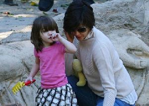 Suri Cruise : katie and suri at park, the little girl is playing with the sand