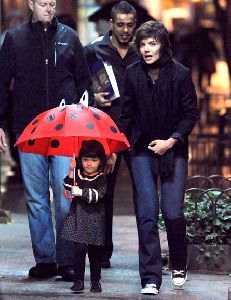 Suri Cruise : Suri holding her red lady-bug cute umbrella accompanied by her mother katie holmes and the bodyguards