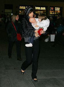 Suri Cruise : Suri with her baby doll is carried by her mother