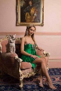 Jessica Jane Clement : on a couch wearing a short green dress and open toe high heals