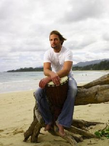 Josh Holloway : on the beach sitting a large tree bench