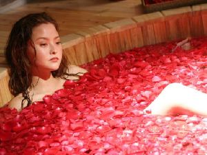 Yuko Aoki : laying in a tub full of red roses petals