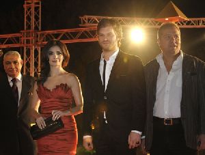 Kivanc Tatlitug on stage with songul oden who is wearing a stunning red dress