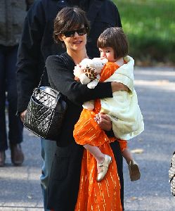 Suri Cruise wearing a stylish orange dress