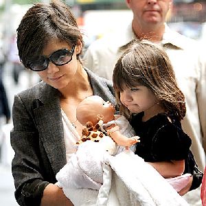 Suri Cruise carried by her mom Kate. Little Suri seems to play a mother of her own for her little baby doll