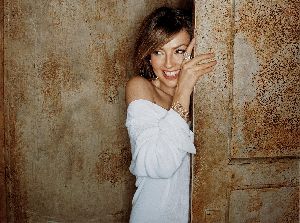 Thalia behind a wall poster