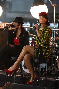 Rihanna singing live wearing a short dress with red high heels