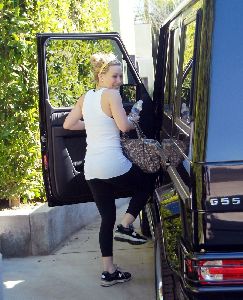 Hilary Duff about to get in her car with a bottle of water after getting out of the gym