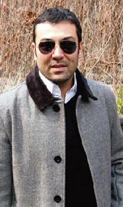 Saruhan Hunel wearing a gray coat and dark sunglasses