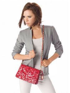 Victoria Beckham : posing for the camera as she carries an-up-to-date red bag