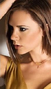 Victoria Beckham : wearing a golden cross simple necklace