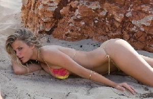 Brooklyn Decker laying on the beach sand