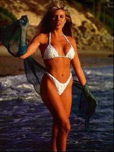 linda sobek on the beach wearing a white bikini and a Chiffon navy shawl