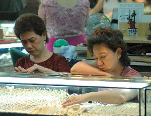 Cities thailand : two sad girls working in a goldsmith shop.