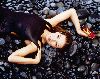 Thalia wallpaper laying on black beach stones