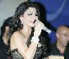 Haifa Wehbe : haifa wehbe signing on stage wearing a black dress designed in a multi-colored-jewelery fashion style