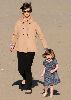 Suri Cruise : Katie in a light orange coat is wearing dark sunglasses with her daughter suri in a windy day