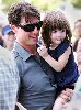 Suri Cruise : Tom Cruise wearing sunglasses and carrying his little daughter Suri who is wearing a Navy dress