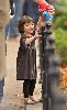 Suri Cruise : Suri Cruise playing with her stuffed bear, dressed wearing a grey velvet dress having in Union Square Park