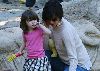 Suri Cruise : katie and suri at park, the little girl is playing with the sand