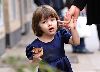 Suri Cruise : in New York City Suri is eating a cupcake, there is chocolate all over her mouth, how cute