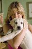 Jennifer Aniston hugging a cute white puppy on the set from Marely and me movie premiere