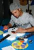 Josh Holloway : coloring a guitar with his fingers at a Guitar Charity Event