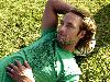 Josh Holloway : laying down on grass wearing a printed green tshirt