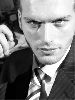 Kivanc Tatlitug : black and white face closeup wearing a suit and a neck tie