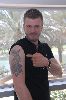 Kivanc Tatlitug pointing to his arm tattoo