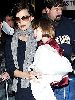 Suri Cruise with Katie Holmes who is wearing a woolen gray neck scarf