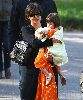 Suri Cruise wearing a stylish orange dress