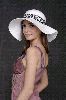 Songul Oden looking stylish in a huge white hat and a simple light maron dress