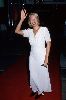 Linda Kozlowski : waving to the fans at a movie premiere wearing a white dress