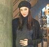 sema simsek pregnant and wearing a dark gray sweater and woolen hat