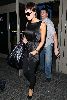 Victoria Beckham at Lax Airport wearing a dark satin mini-dress and black leggings matched with a large handbag