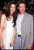 Actor hugh jackman standing beside a pretty woman that IS wearing a white dress.